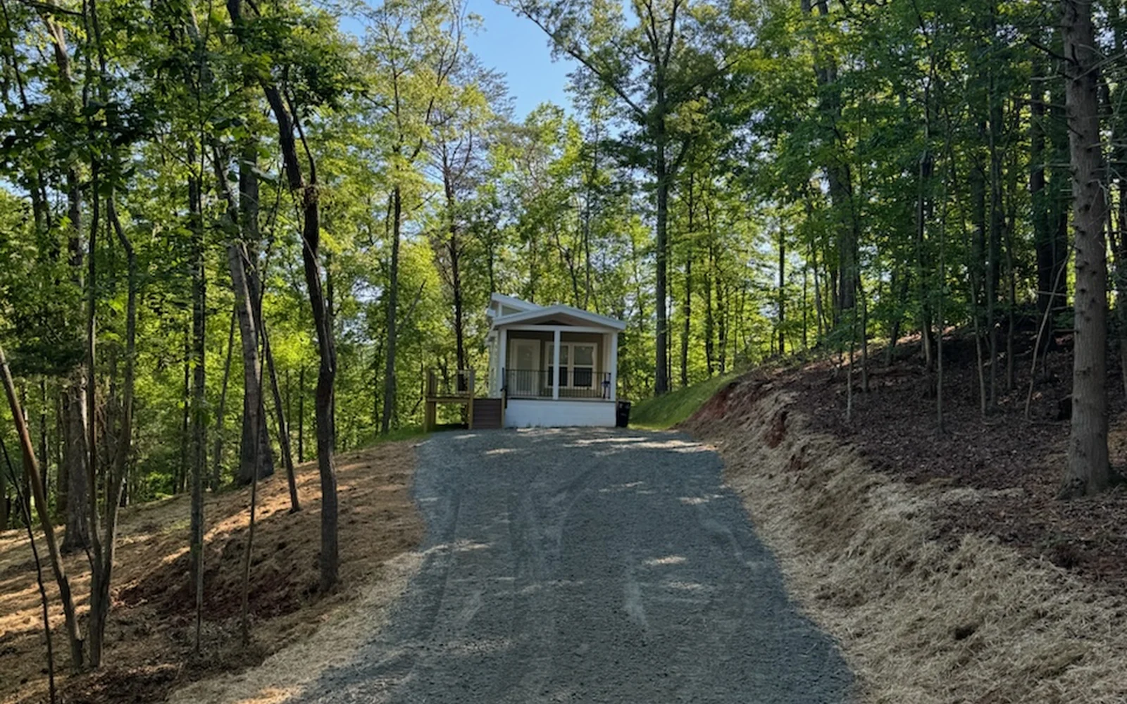 Gravel access drive running through a cleared corridor in the woods